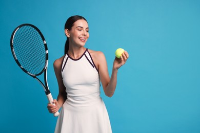 Happy tennis player with racket and ball on light blue background, space for text