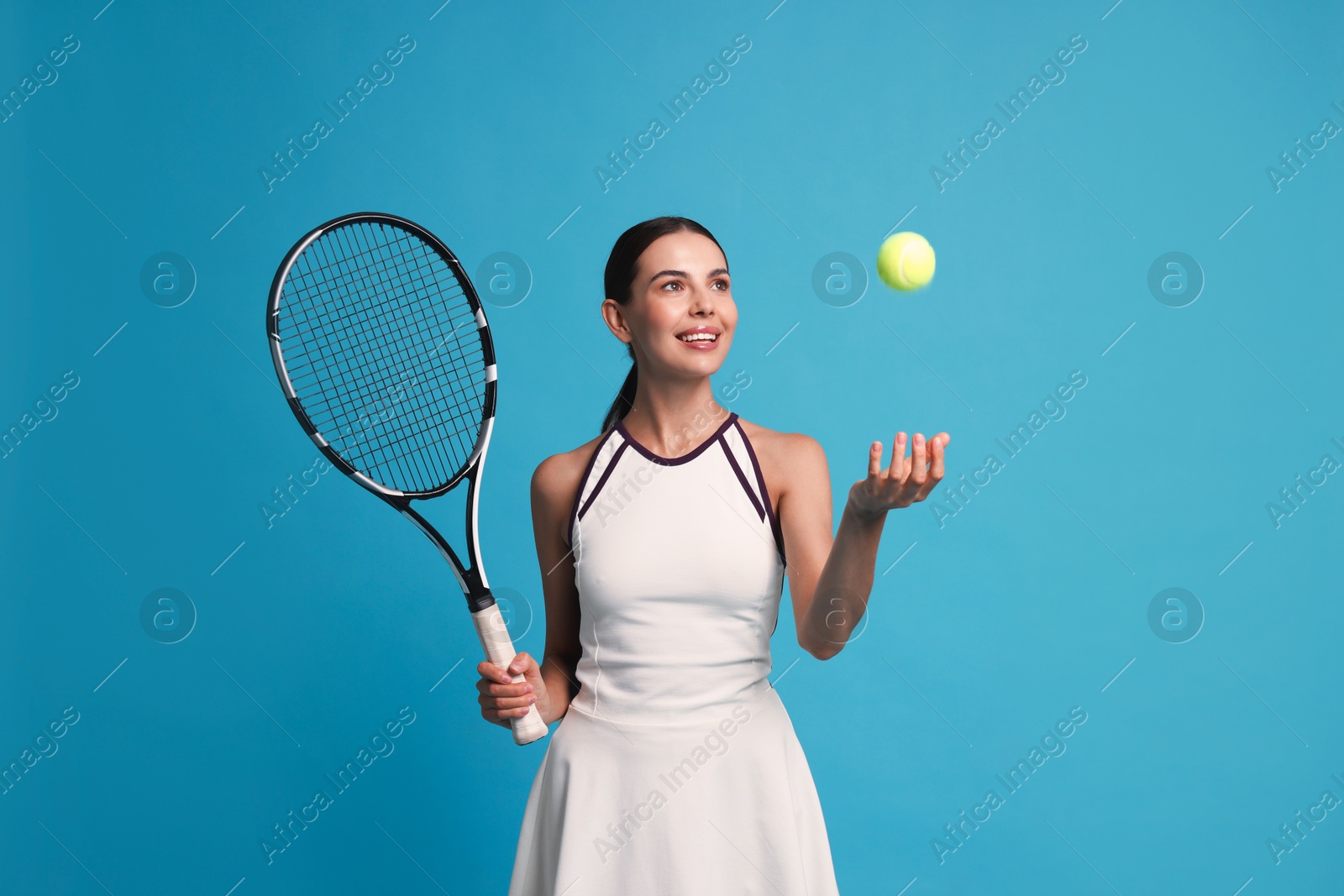 Photo of Happy tennis player with racket and ball on light blue background