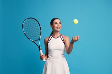 Photo of Happy tennis player with racket and ball on light blue background