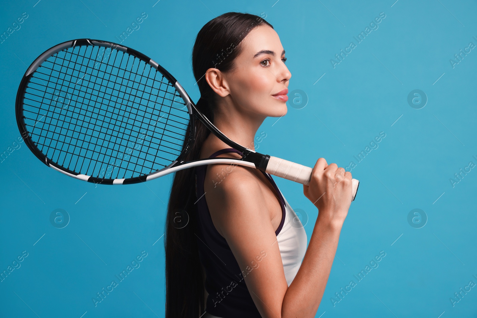 Photo of Beautiful young woman with tennis racket on light blue background