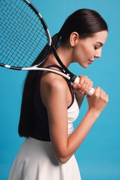 Photo of Beautiful young woman with tennis racket on light blue background