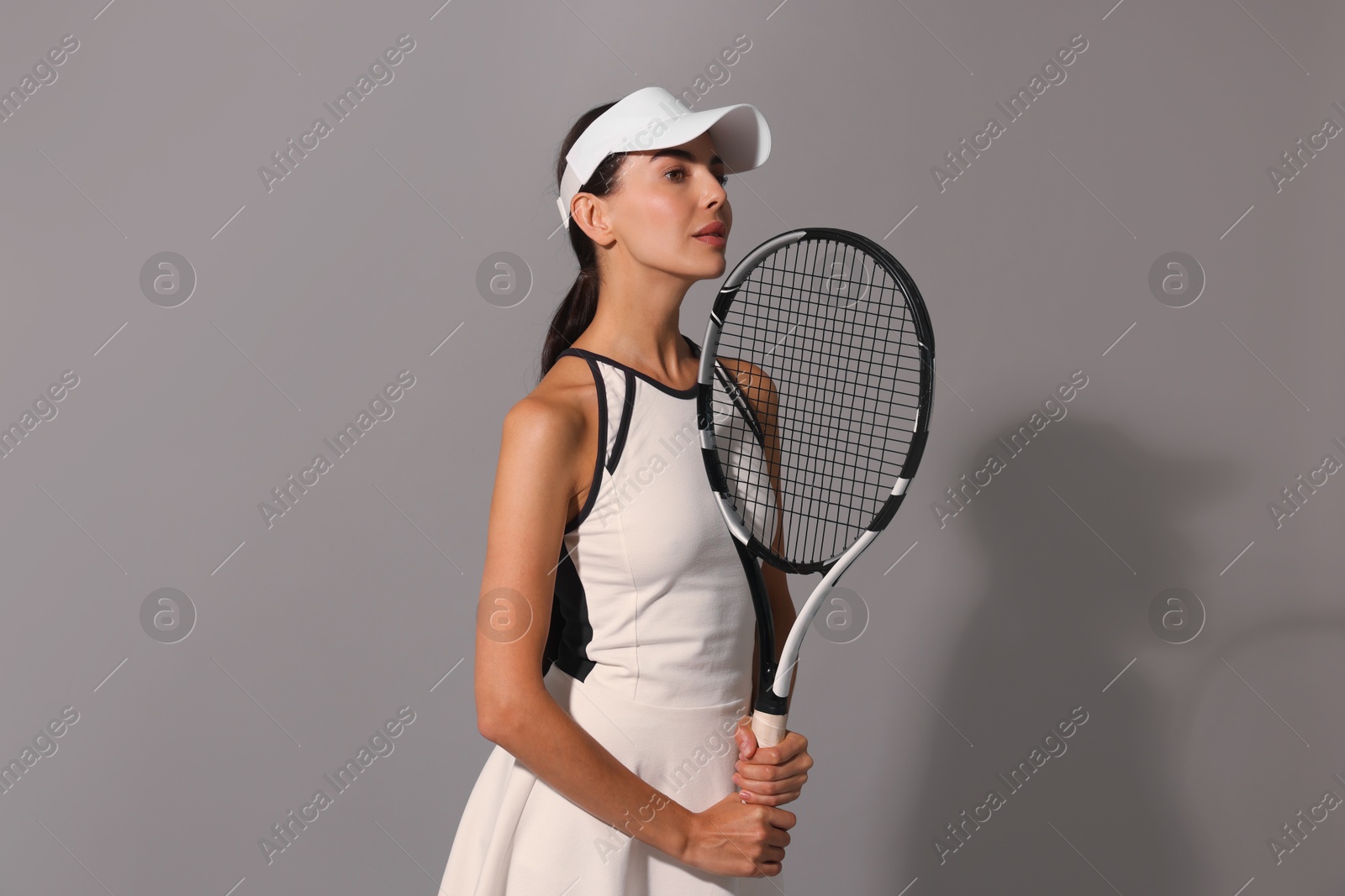 Photo of Tennis player with racket on grey background