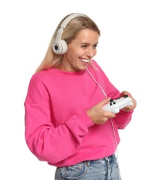 Happy woman in headphones playing video games with controller on white background