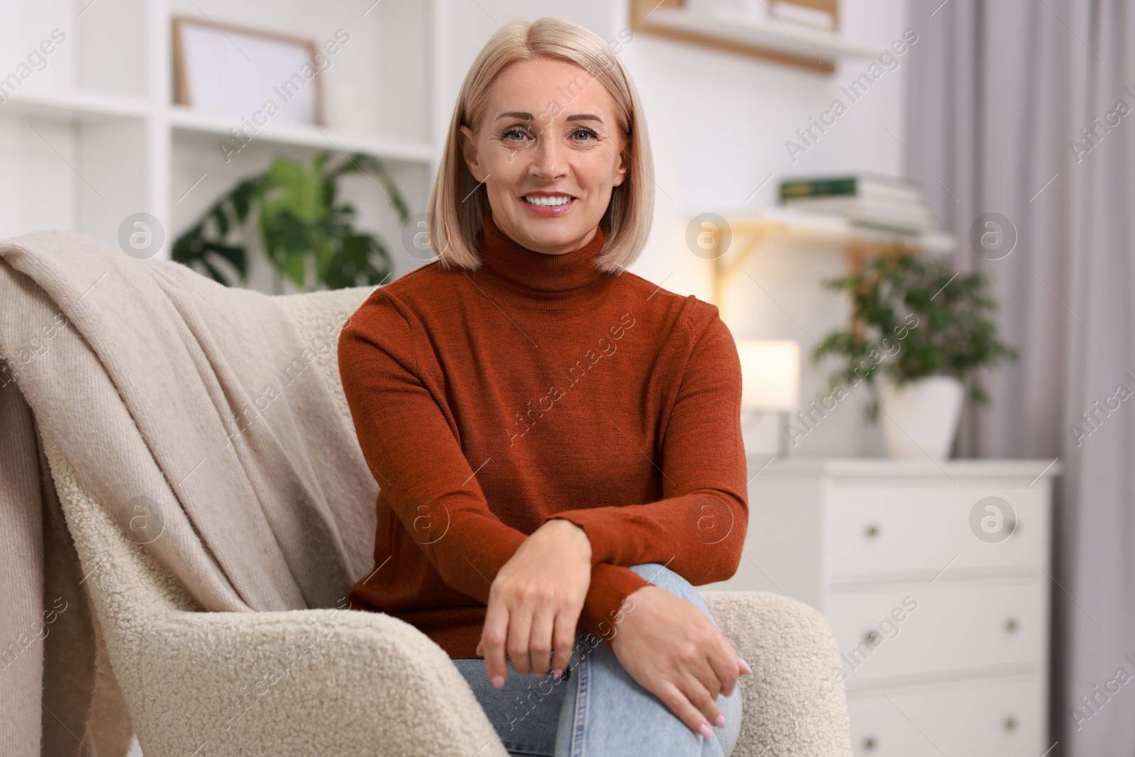 Photo of Portrait of smiling middle aged woman on armchair at home