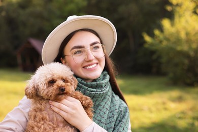 Smiling woman with cute dog in autumn park. Space for text