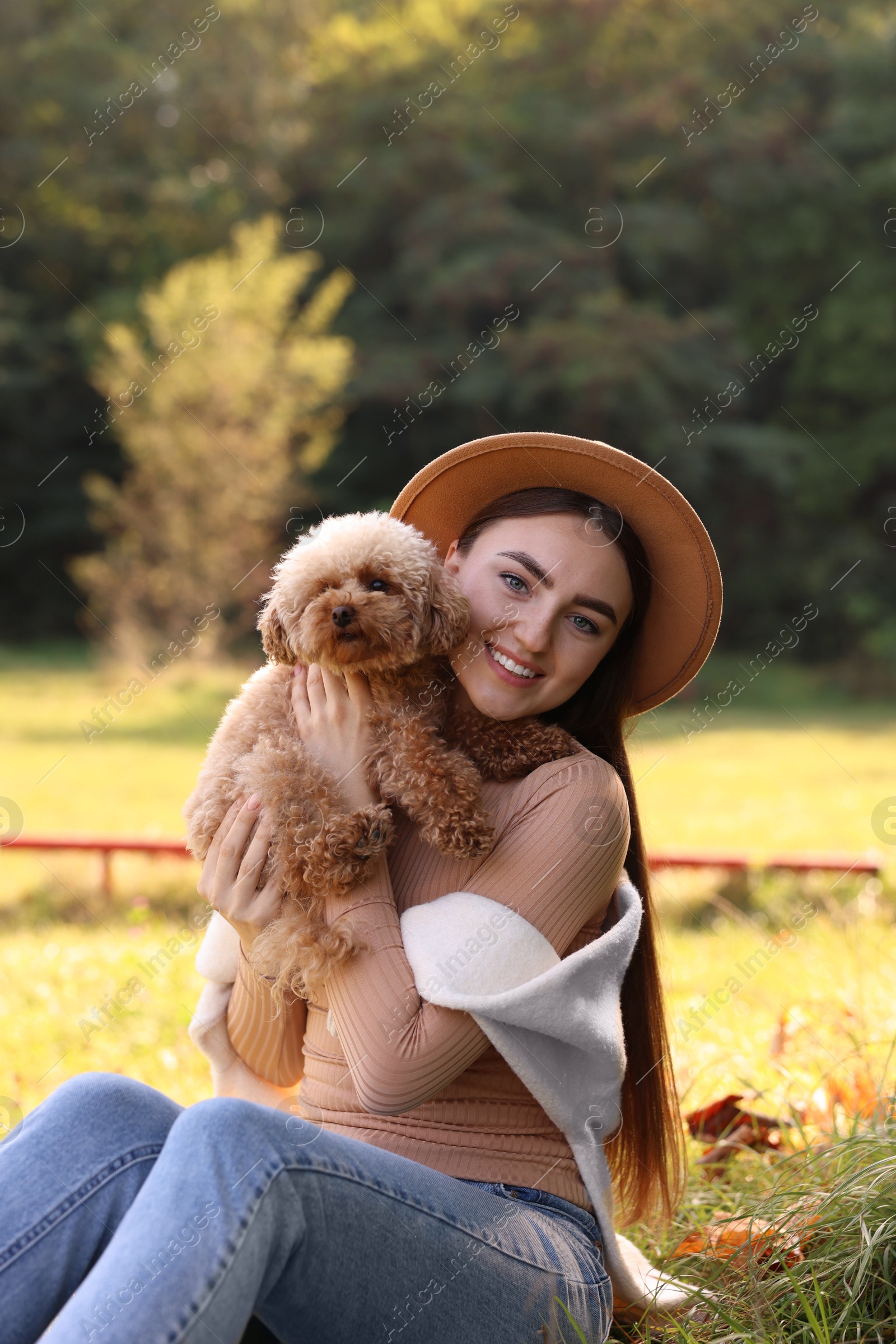 Photo of Smiling woman with cute dog in autumn park