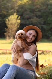 Photo of Smiling woman with cute dog in autumn park