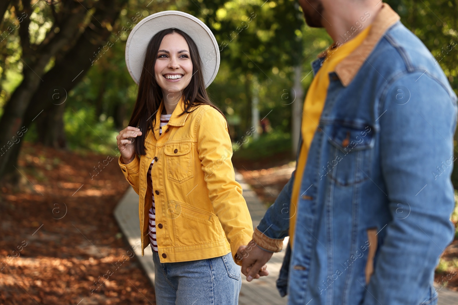 Photo of Beautiful couple walking together in autumn park, selective focus