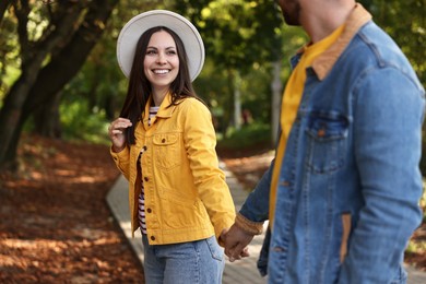 Beautiful couple walking together in autumn park, selective focus