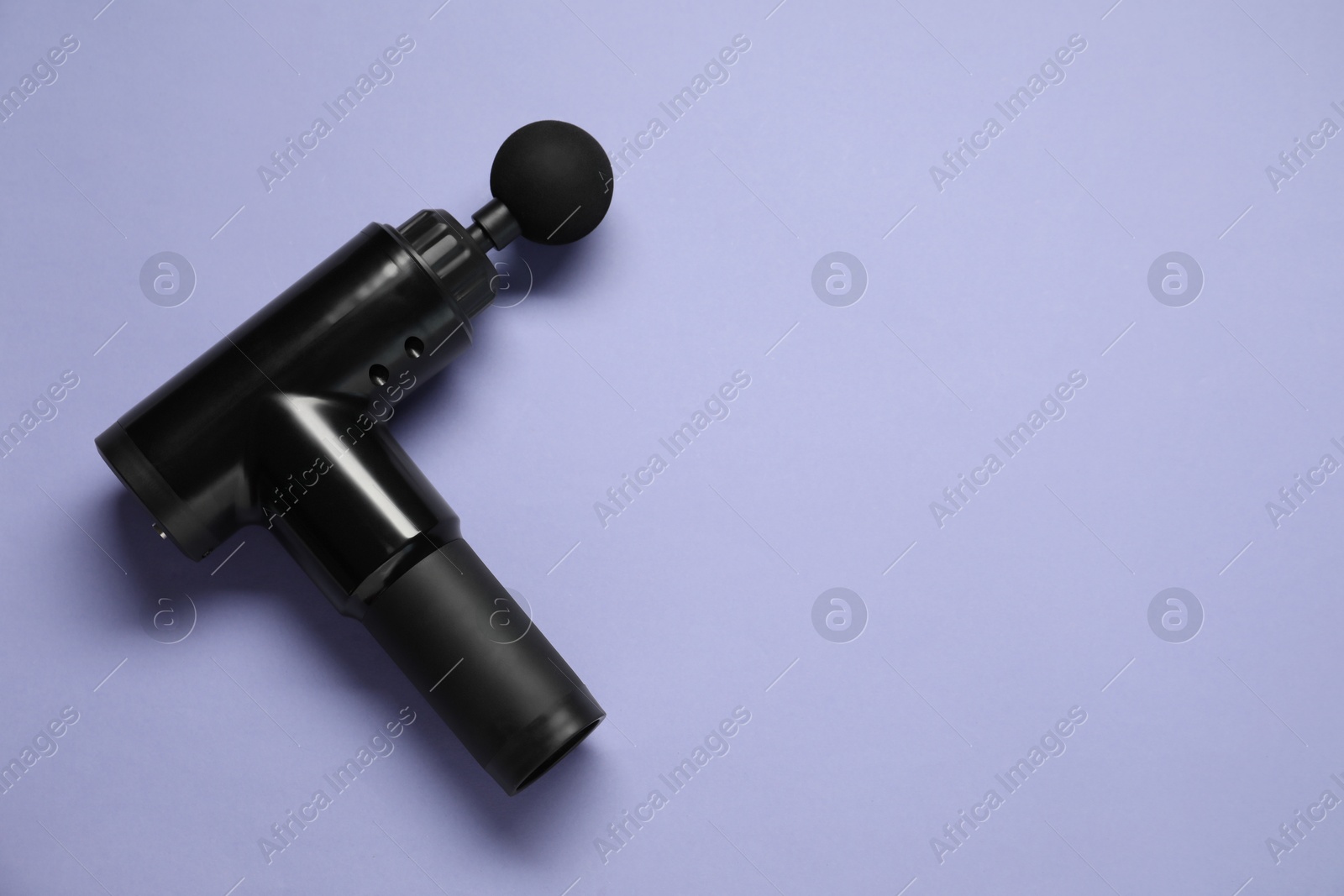 Photo of One black percussive massager on light background, top view. Space for text