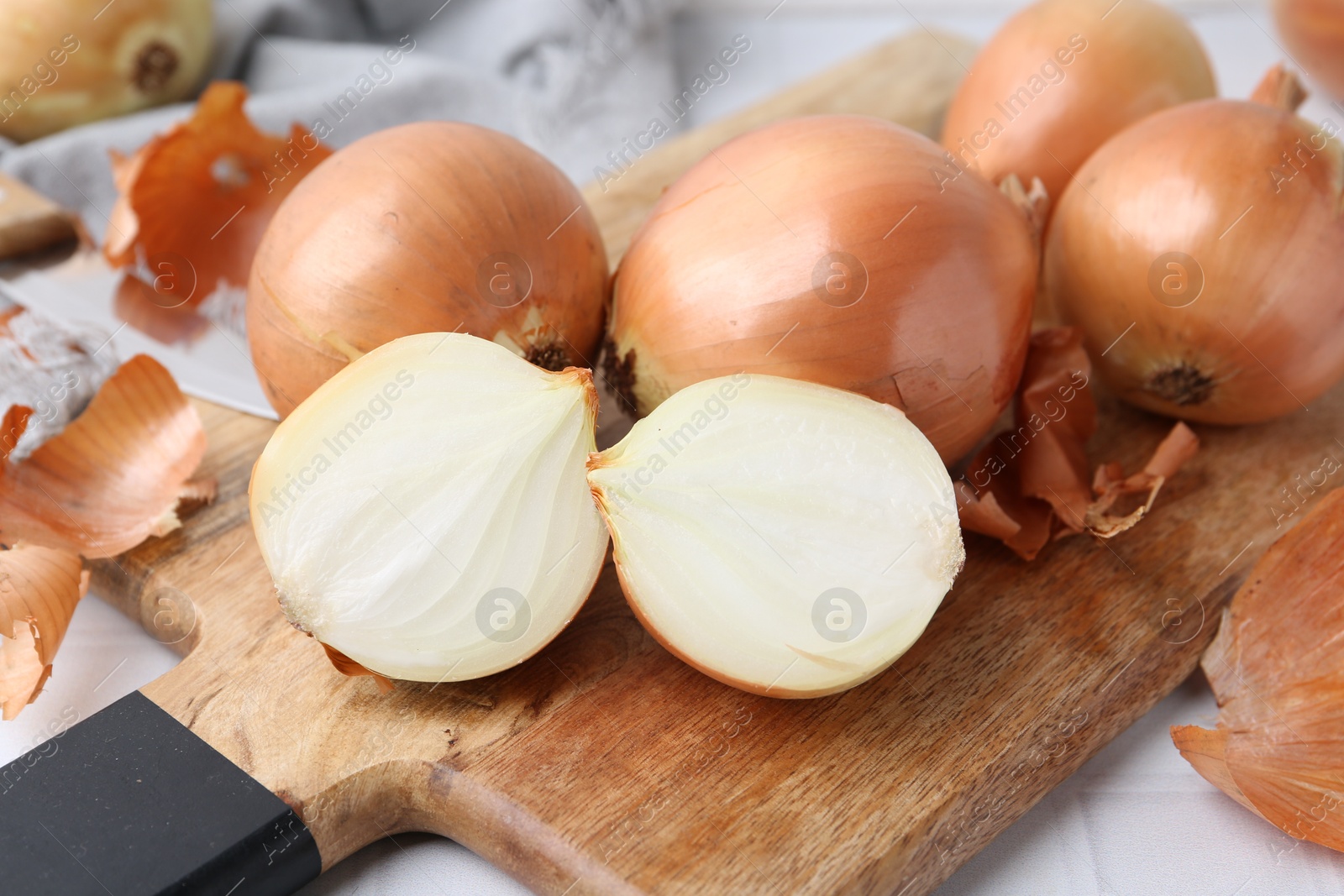 Photo of Fresh onions with peels on table, closeup