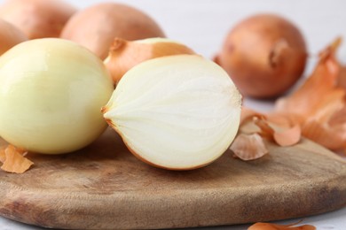 Photo of Fresh onions with peels on table, closeup