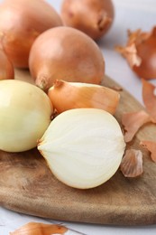 Fresh onions with peels on table, closeup