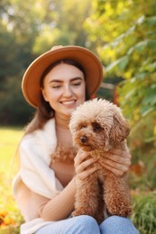 Smiling woman with cute dog in autumn park