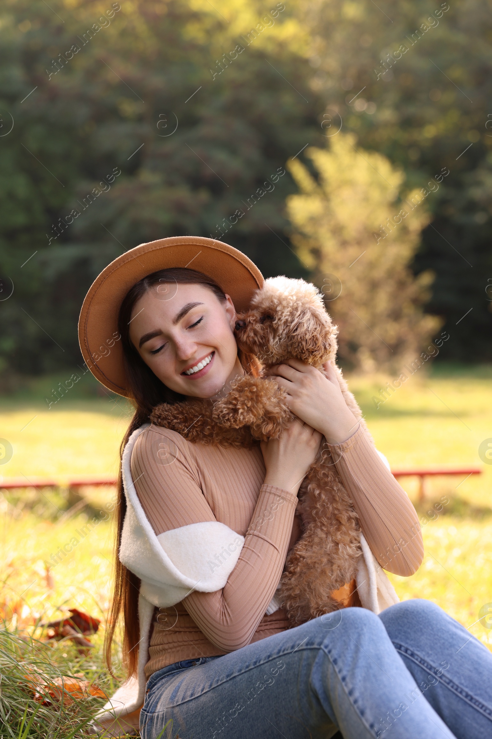 Photo of Smiling woman with cute dog in autumn park