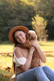 Smiling woman with cute dog in autumn park