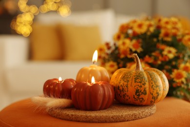 Photo of Burning candles, pumpkin and spikelets indoors. Autumn atmosphere