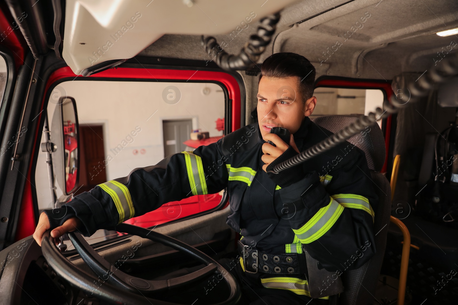 Photo of Firefighter using radio set while driving fire truck