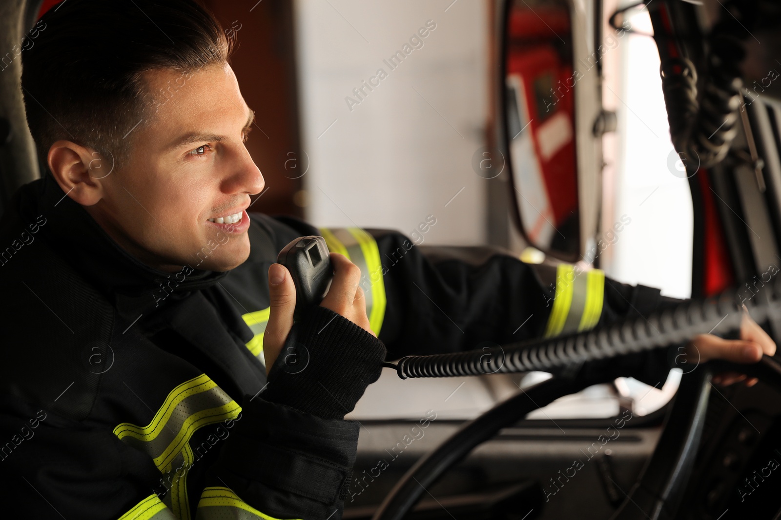 Photo of Firefighter using radio set while driving fire truck