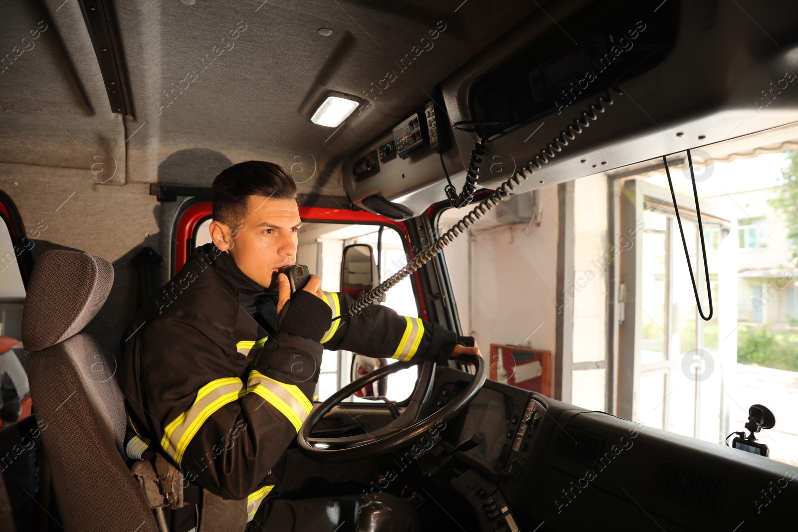 Photo of Firefighter using radio set while driving fire truck