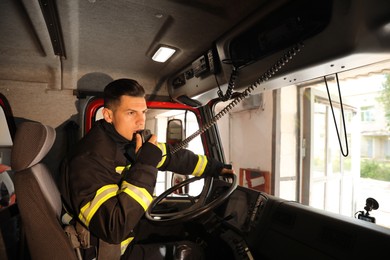 Firefighter using radio set while driving fire truck