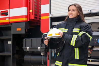 Photo of Portrait of firefighter in uniform with helmet near fire truck