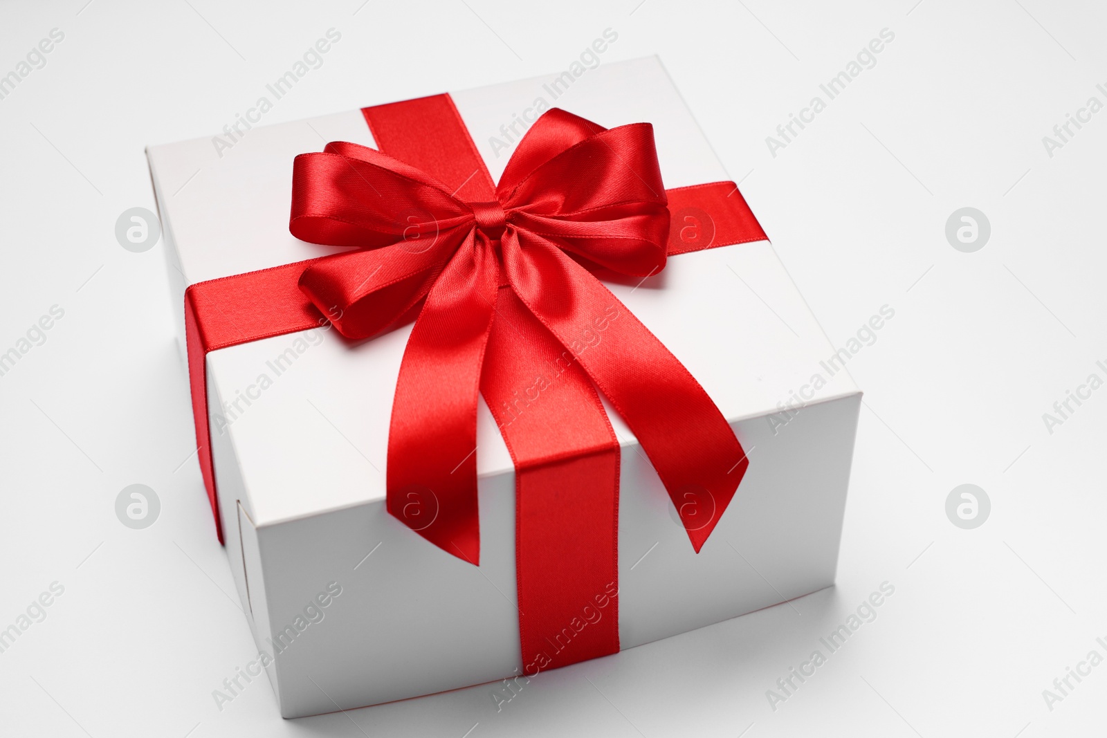 Photo of Gift box with red bow on light grey background