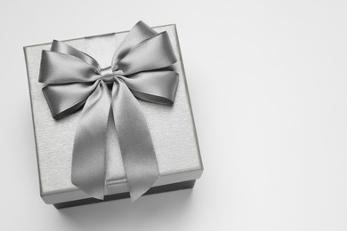 Photo of Gift box with bow on light grey background, above view. Space for text