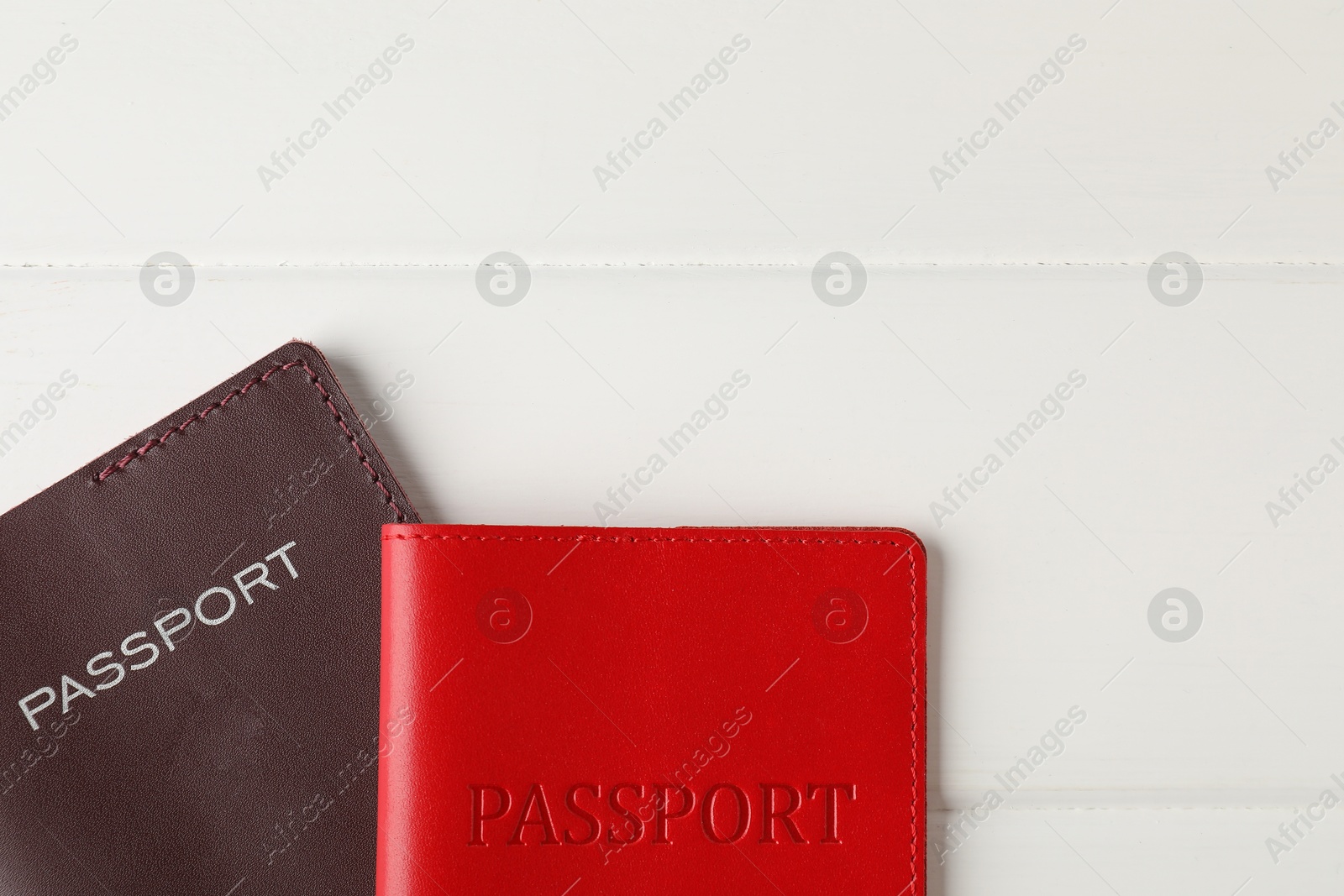 Photo of Passports on white wooden table, flat lay. Space for text