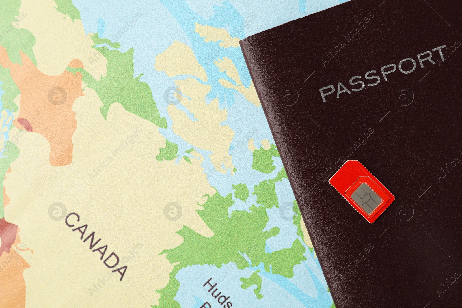 Photo of Passport and Sim card on world map, top view