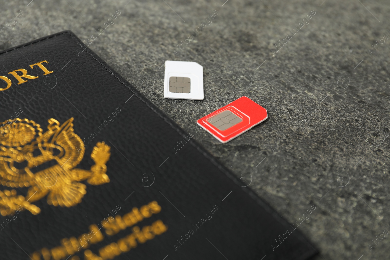 Photo of Passport and SIM cards on grey textured table, closeup