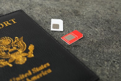 Photo of Passport and SIM cards on grey textured table, closeup