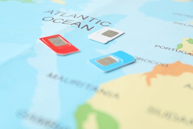 Photo of Group of SIM cards on world map, closeup