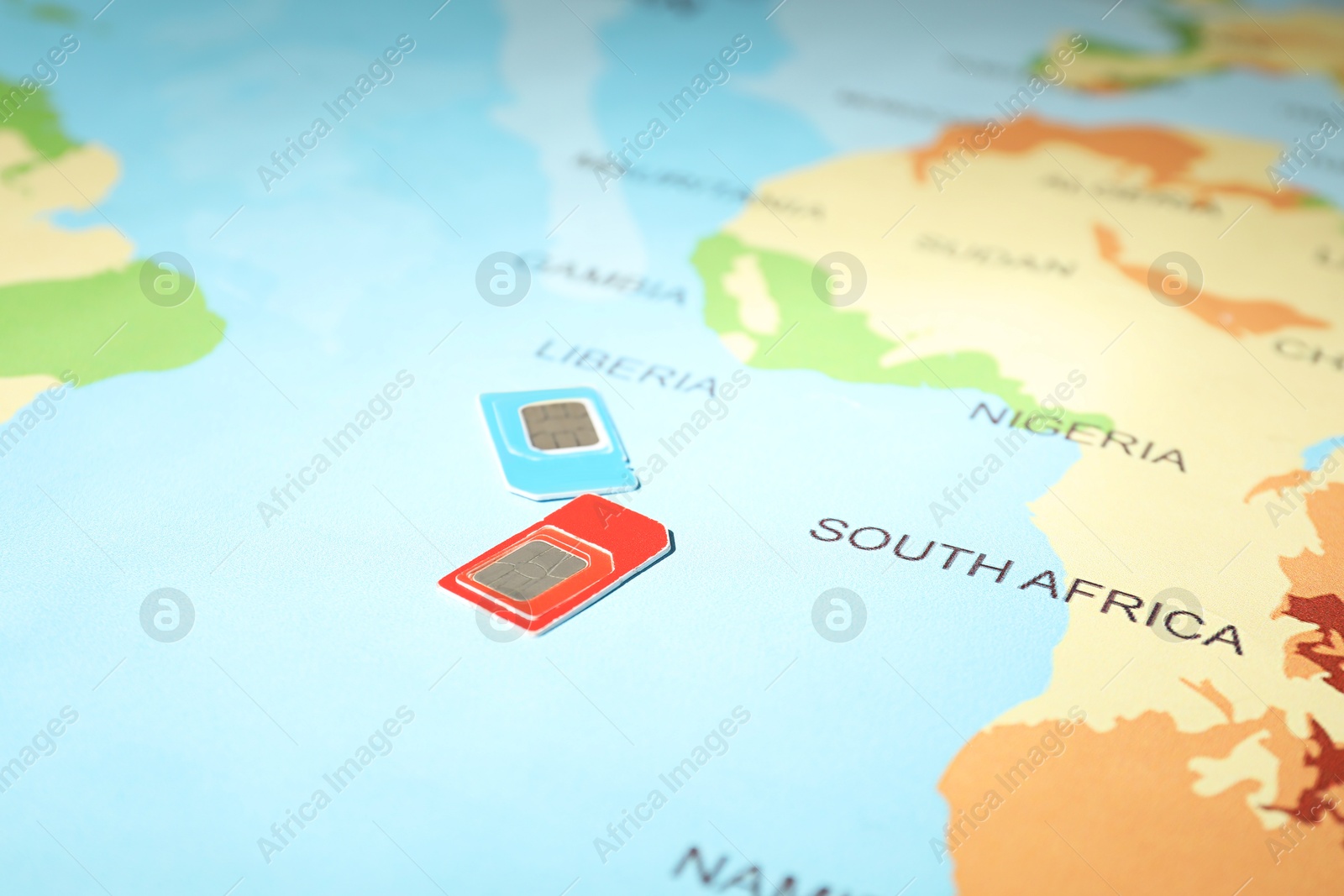 Photo of Modern SIM cards on world map, closeup