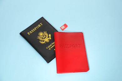 Modern SIM card and passport on light blue background