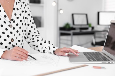 Architect making engineering drawing at table in office, closeup