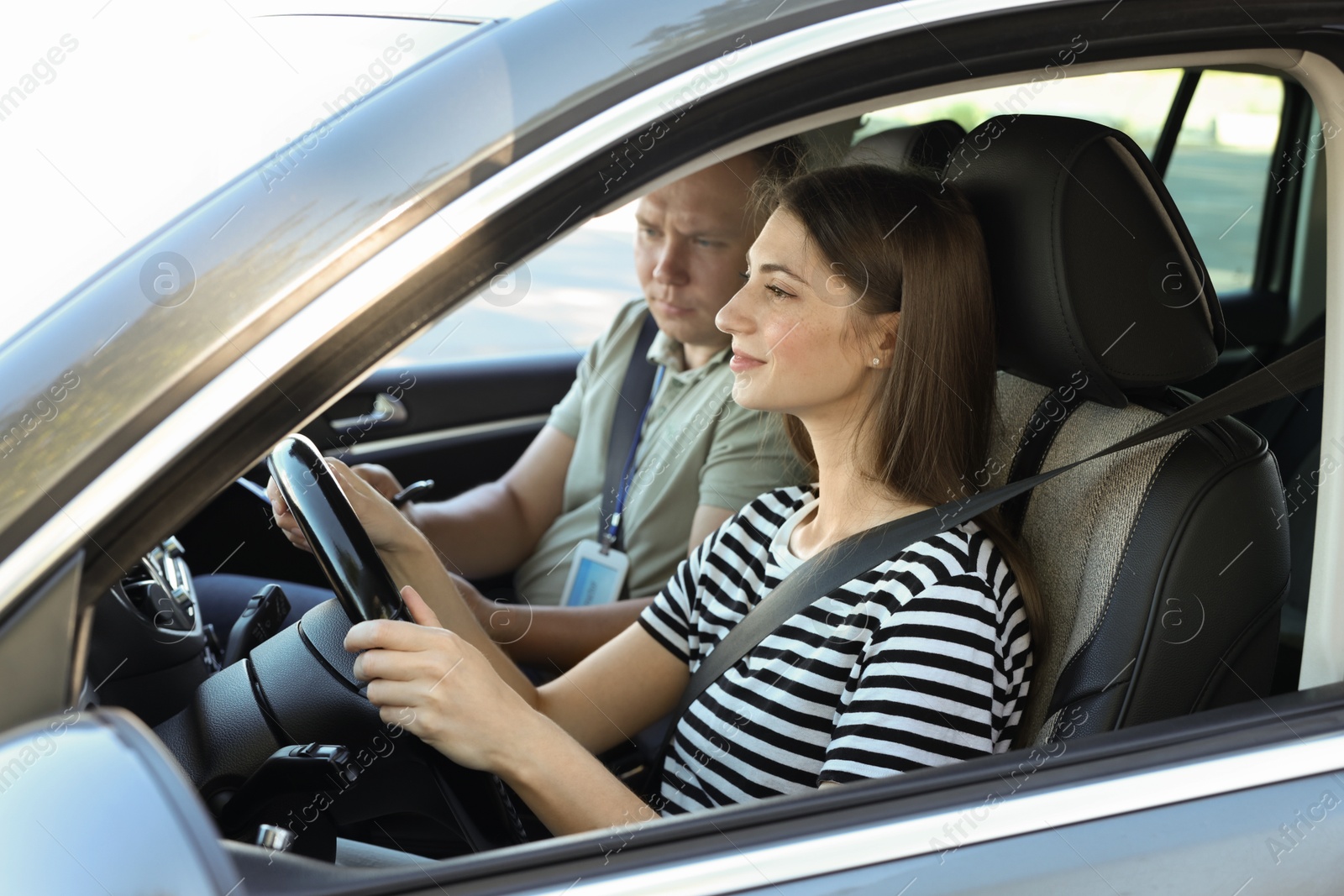 Photo of Driving school. Student passing driving test with examiner in car