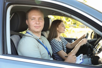 Photo of Driving school. Student passing driving test with examiner in car