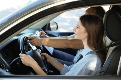 Photo of Driving school. Student passing driving test with examiner in car