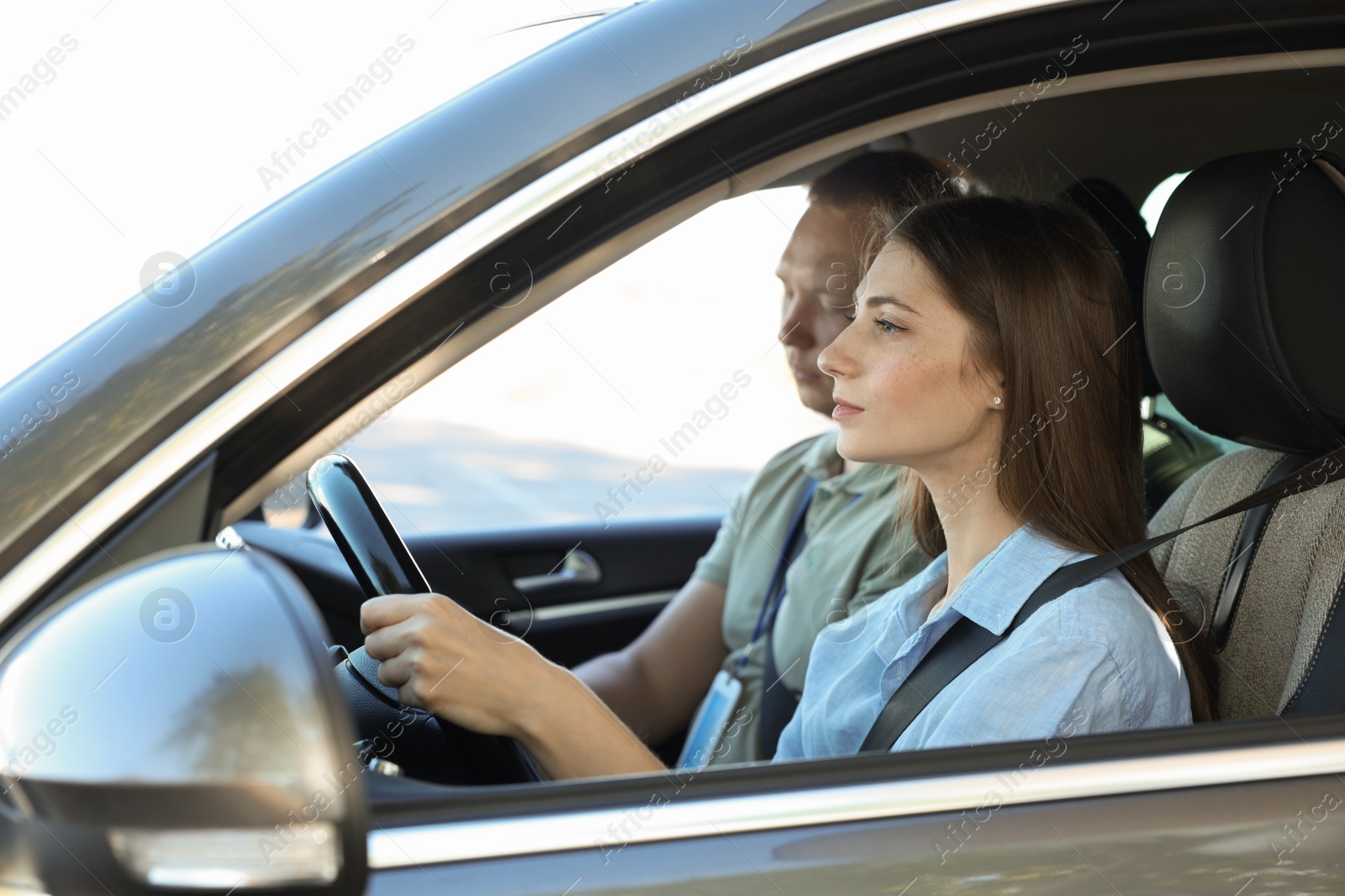 Photo of Driving school. Student passing driving test with examiner in car