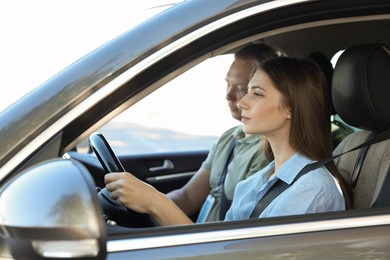 Photo of Driving school. Student passing driving test with examiner in car