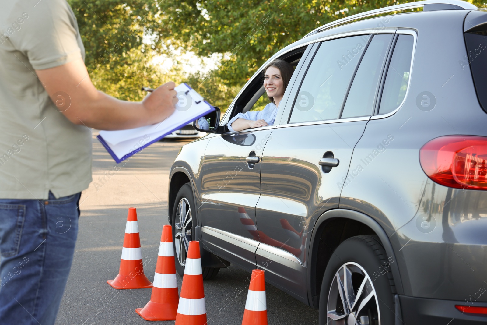 Photo of Examiner with clipboard during exam at driving school test track, closeup