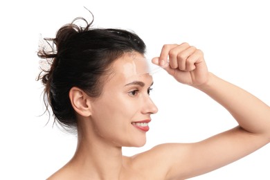 Photo of Smiling woman peeling off face mask on white background