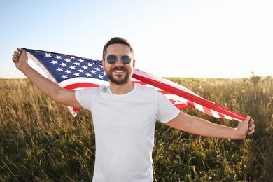 Happy man with flag of USA outdoors