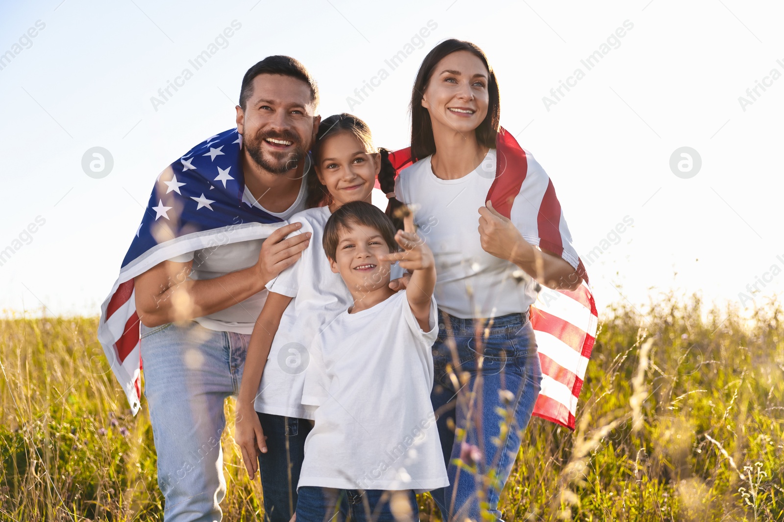 Photo of Happy family with flag of USA outdoors