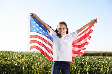 Happy girl with flag of USA outdoors