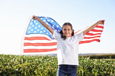 Little girl with flag of USA outdoors