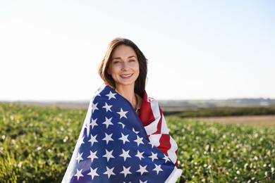 Photo of Happy woman with flag of USA outdoors