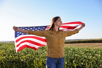 Happy woman with flag of USA outdoors