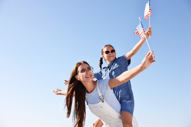 Photo of Happy mother and daughter with flags of USA outdoors